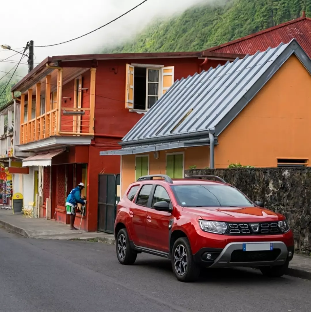 Voiture de location circulant sur une route panoramique à La Réunion avec vue sur les montagnes, les paysages tropicaux et les plus beaux panoramas de l’île.
